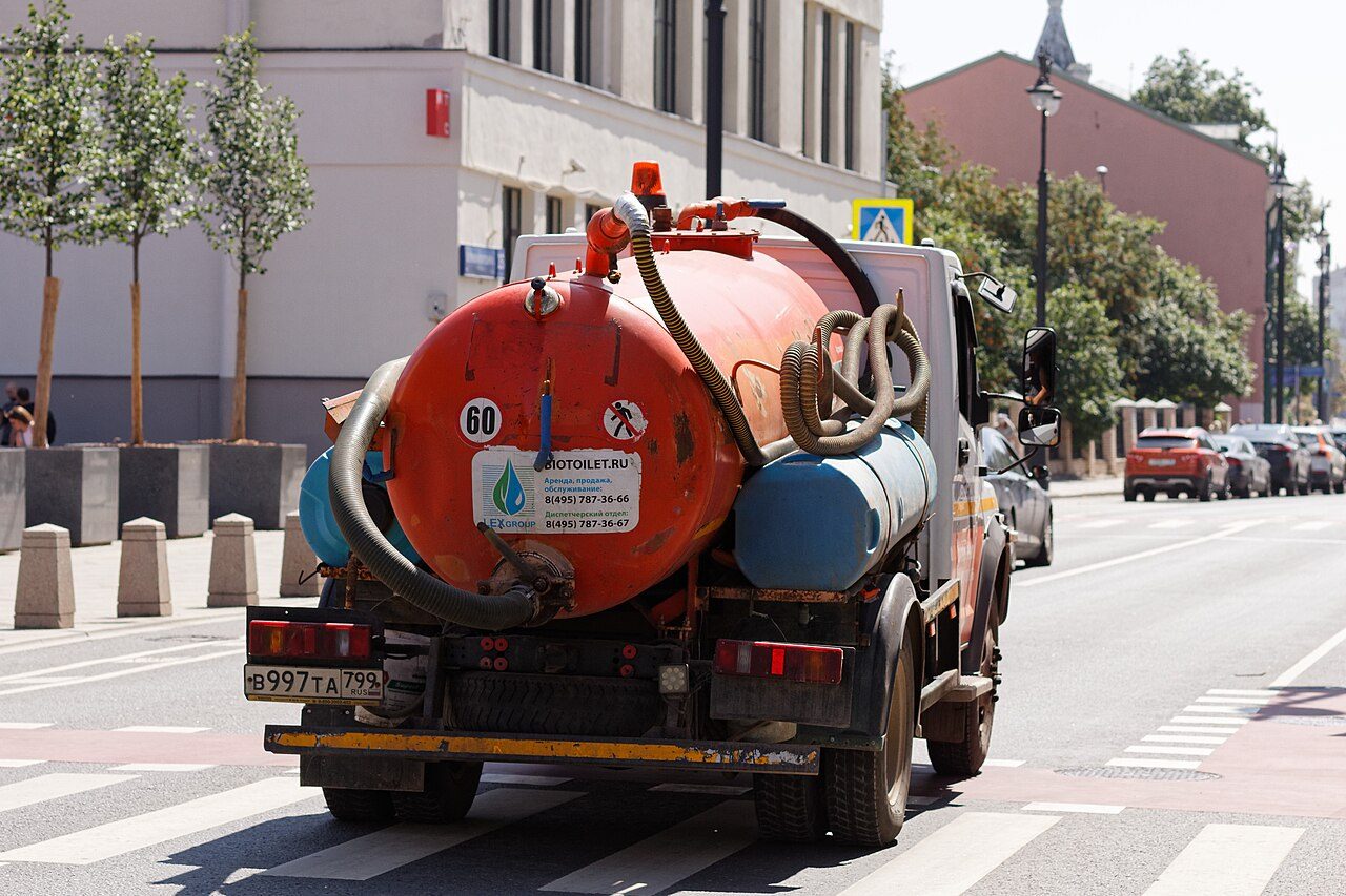Vacuum pump truck parked at a commercial property
